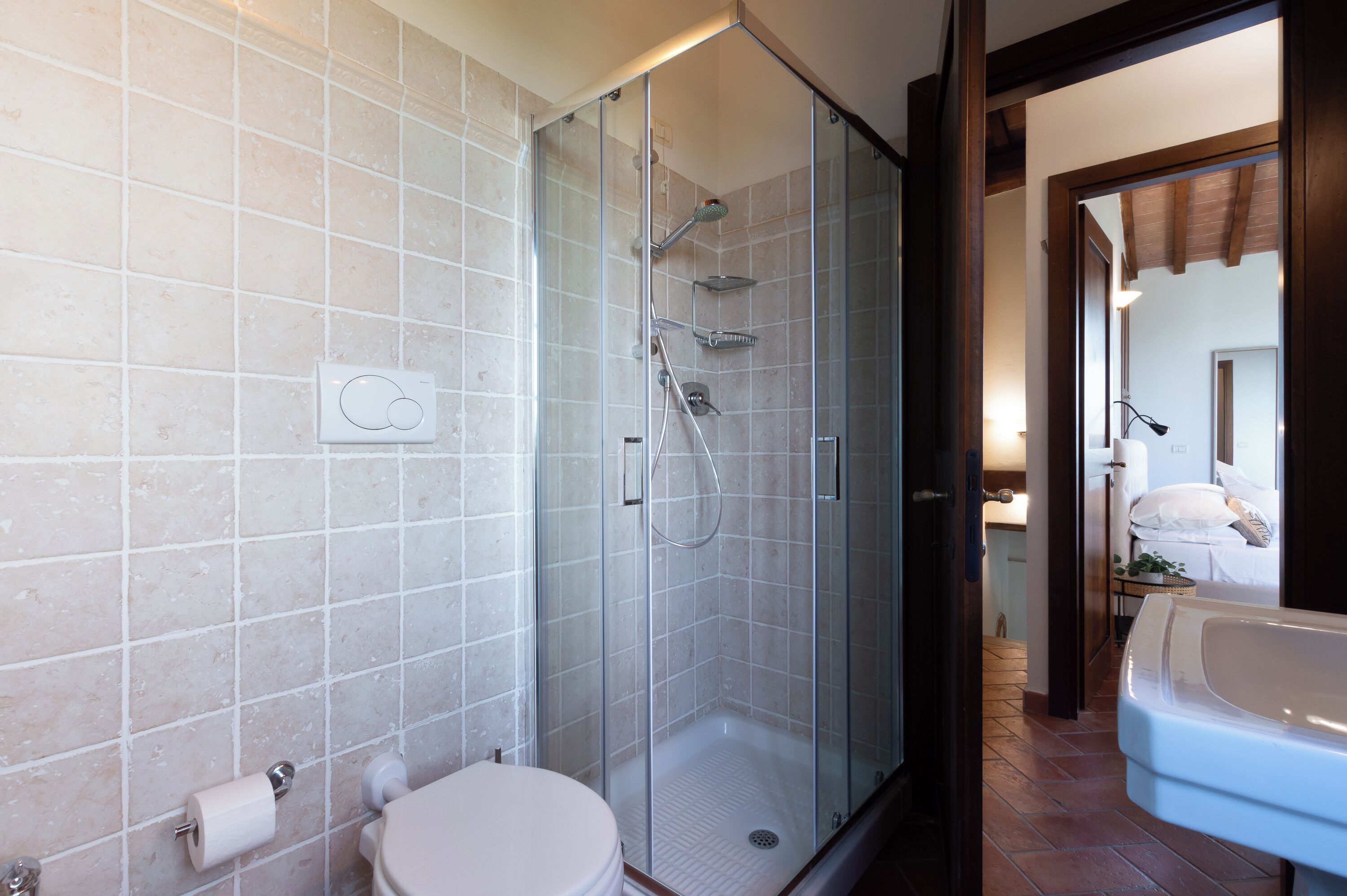 A modern bathroom with a glass-enclosed shower, a toilet, and a bathtub.