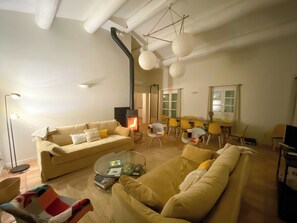 Ein Wohnzimmer mit einer Couch, einem Couchtisch, einem Kamin und einem Essbereich mit Stühlen und einem Tisch.