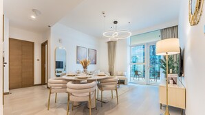 Un espace repas moderne avec une table ronde, des chaises rembourrées et un lampadaire.