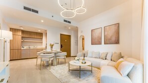 Un salon moderne avec un canapé blanc, une table basse et un coin repas comprenant une table ronde et des chaises.