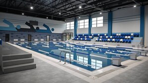 A large indoor swimming pool with multiple lanes, a seating area with blue and white chairs, and a modern architectural design with a high ceiling and large windows. - Arena Hotel Yevlakh (Yevlakh)