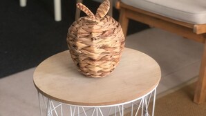 A woven basket on a round table with a white wireframe base, set in a room with wooden chairs and a white table. - Cosy studio Annecy - 10 min from center and train station (Annecy)