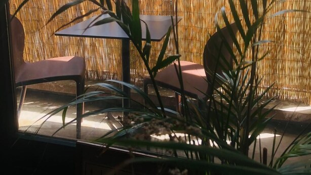 An outdoor seating area with a view of a cityscape, featuring a bamboo fence and potted plants. - Cosy studio Annecy - 10 min from center and train station (Annecy)