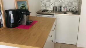 A compact kitchen with a wooden countertop, a coffee maker, a kettle, and a sink. - Cosy studio Annecy - 10 min from center and train station (Annecy)