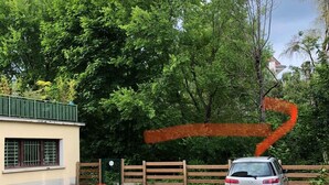 A parking area with a car, trees, and a building with a green roof. - Cosy studio Annecy - 10 min from center and train station (Annecy)