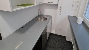 A compact kitchenette with a stainless steel sink, a small countertop, and a window. - Fantastic Inn Warsaw - Jasna (Warsaw)