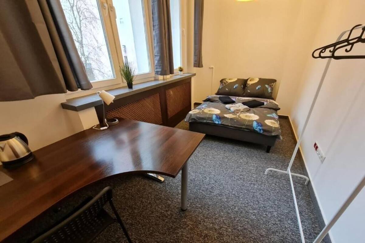 Une petite pièce comprenant un lit, un bureau et une chaise.