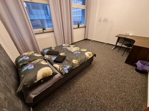 Una camera da letto con un letto, una scrivania e una sedia.
