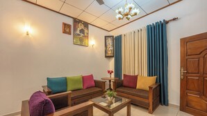 A living room with a sofa set, a coffee table, and a wooden door. - Sea Bloom Villa (Thalaramba)