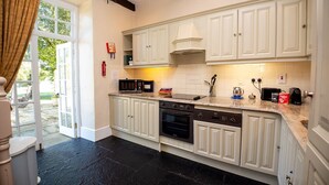 Une cuisine avec des meubles blancs, un four à micro-ondes, une cuisinière et un lave-vaisselle.