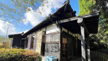 A traditional Japanese building with a sloped roof, wooden sliding doors, and a covered entrance.