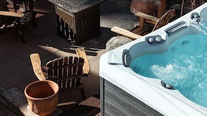 Boblebad med træterrasse, stole, en terracotta krukke og en stenbænk.