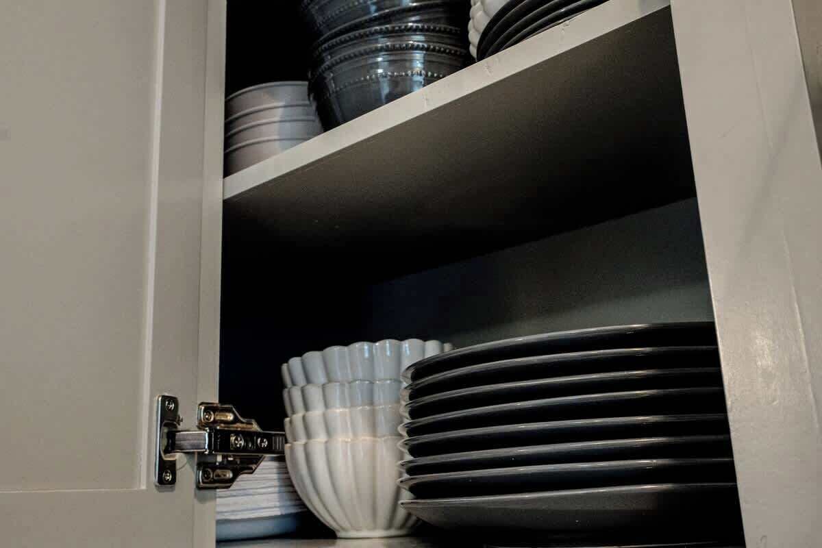 A cabinet with stacked plates and bowls.