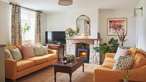 A cozy living room with two sofas, a coffee table, a fireplace, a TV, and a painting on the wall. - No.2 Coastguards Cottage, welcoming holiday home near the coast (West Lulworth)