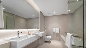 A modern bathroom with a large mirror, two sinks, a toilet, and a glass-enclosed shower. - 2BR M CF7B Pet Friendly Stay (Dubai)