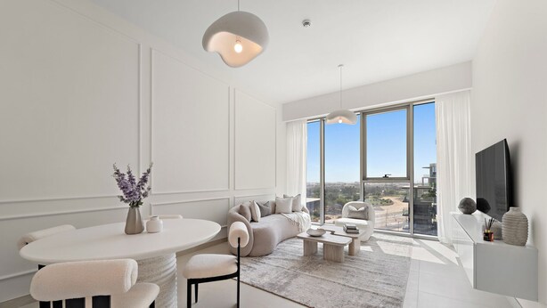 A modern living room with a dining area, large windows, and a flat-screen TV. - 2BR M CF7B Pet Friendly Stay (Dubai)