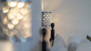 Primer plano de un objeto metálico cubierto de diamantes, posiblemente un adorno o parte de un mueble, con un fondo difuminado que muestra efectos de luz bokeh suaves.