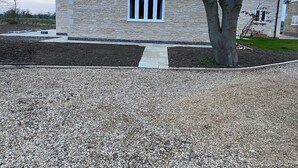 Un bâtiment en pierre avec une fenêtre et un arbre devant.