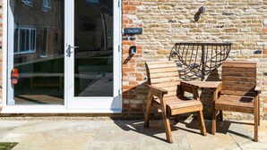 A brick wall with a sign reading "The Sett" and a glass door entrance. - The Sett: cosy riverside home (Stamford)