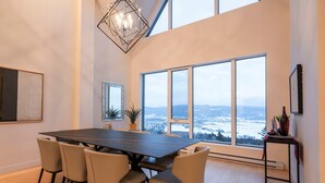Un comedor con una mesa grande, sillas y vistas amplias a través de ventanales.