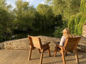 Two wooden chairs facing a body of water with trees in the background. - Fletland Mill: 18th century mill near Stamford (Stamford)