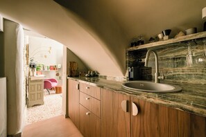 Una cocina con armarios de madera, encimera de mármol y pileta.