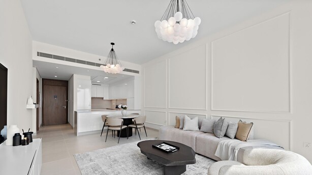 Una sala de estar moderna con un sofá, una mesa de centro y un comedor con cocina al fondo.