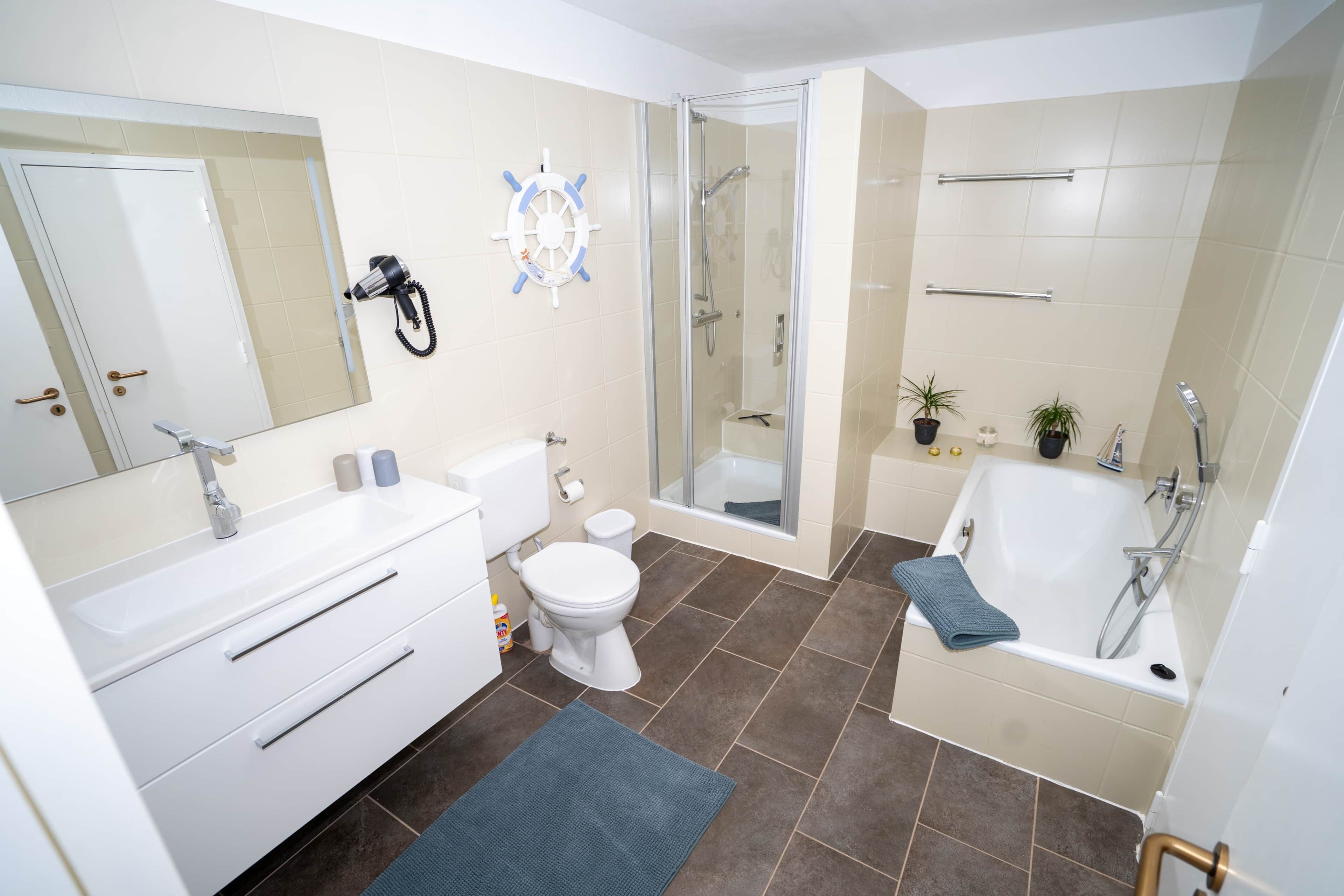 Un baño moderno con ducha, inodoro, lavabo y bañera.