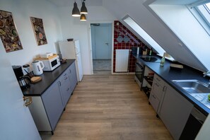 A modern kitchen with a microwave, kettle, and a Samsung dishwasher. - Emma Vacation Rental (Friedrichskoog)