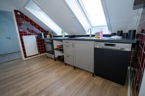 Una cocina moderna con tragaluz, lavavajillas y horno empotrado.