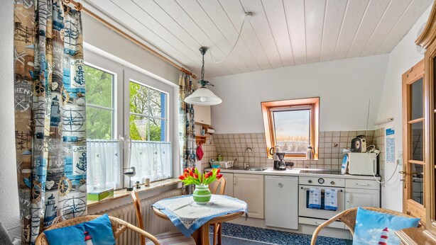 A cozy kitchen with a dining area, wooden furniture, and nautical-themed decor. - Apartment 2, Upper Floor with Wi-Fi (Hooksiel)
