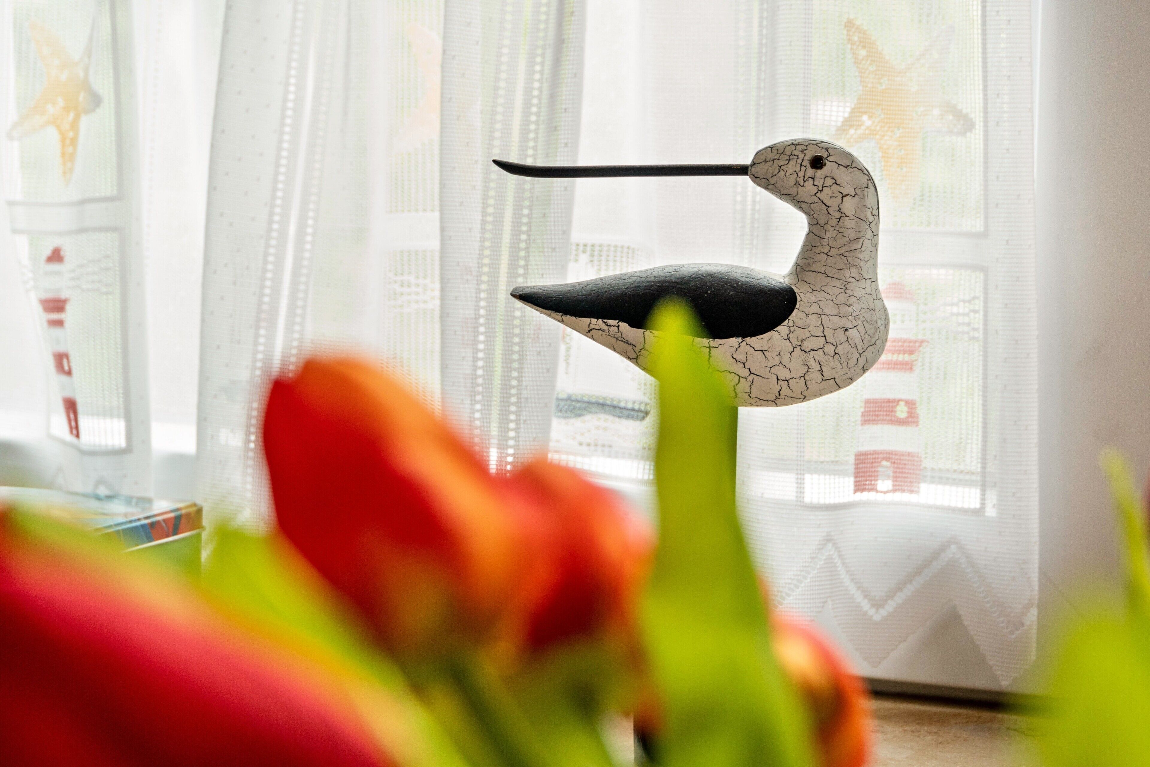 Eine vogelartige Skulptur in einem Raum mit einem Fenster.