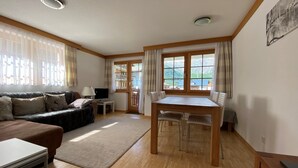 Un espacio habitable amplio con un sofá, una mesa de comedor y un televisor.