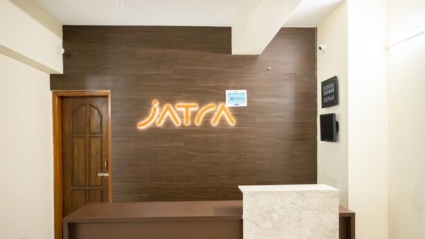 A reception desk with a wooden panel wall and a neon sign above it. - Jatra Flagship Rajshahi City Centre 4 (Rajshahi)