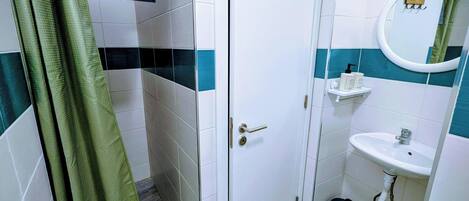 Un baño con ducha, lavamanos e inodoro.