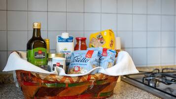 Un piano di lavoro in cucina con un cesto pieno di generi alimentari e bottiglie.
