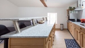 A modern kitchen with a granite countertop, wooden cabinets, and a built-in oven.