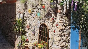 A stone building with a blue door, a small table with chairs, and potted plants. - La Bulle, an authentic and romantic spa (Biot)