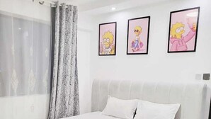 A modern bedroom with a large bed, a window with sheer curtains, and three framed pictures on the wall. - Golden Mango Heights Apartments (Nairobi)