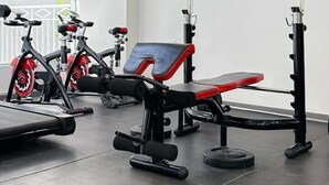 A modern gym with exercise equipment, including treadmills and weight machines. - Golden Mango Heights Apartments (Nairobi)