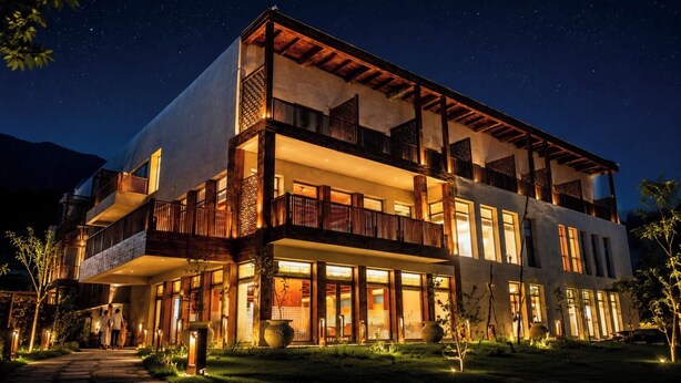 A multi-story hotel with balconies, large windows, and a well-lit exterior at night. - Sost Serena Hotel  (Sost)