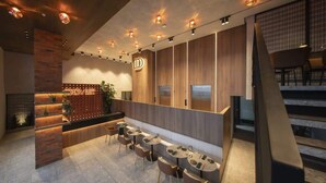 A modern hotel lobby with a reception desk, seating area, and a staircase. - Smart Loft-Style 1br Apt near to shops (Ciudad de Panamá)