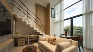 A modern living room with a sofa, coffee table, and a staircase.