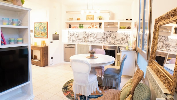 A cozy dining area with a round table, chairs, and a decorative rug. - Conti & Moroni House  (Calenzano)