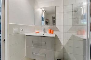 A modern bathroom with a white sink, mirror, and towel rack. - Gîte Les Garrigues – Modern Comfort Near Les Baux-de-Provence, Sleeps 3 (Mouriès)