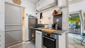 Eine kleine Küche mit Geschirrspüler, Backofen und Kaffeemaschine.