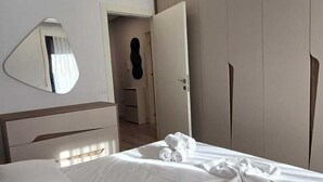 Une chambre d’hôtel avec un lit, un miroir et une armoire.