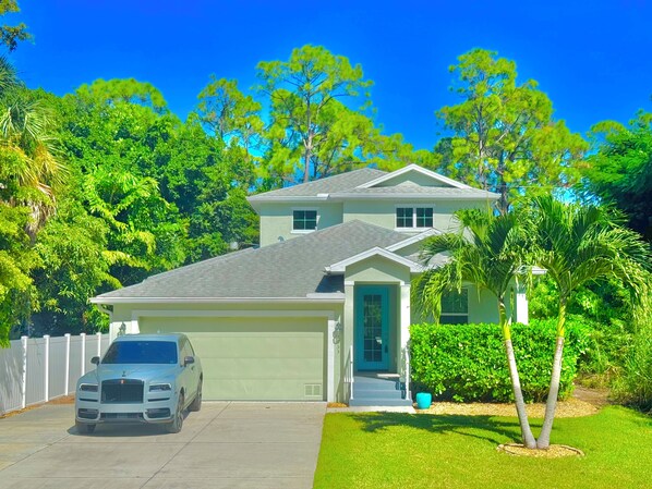 A two-story house with a garage, a driveway, and a lawn. - Peaceful Naples Gateway (Naples)
