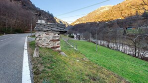 A rural road with a stone building and a house with a sloped roof. - Holiday Home 'Maison Core' with Mountain View and Wi-Fi (Fontainemore)