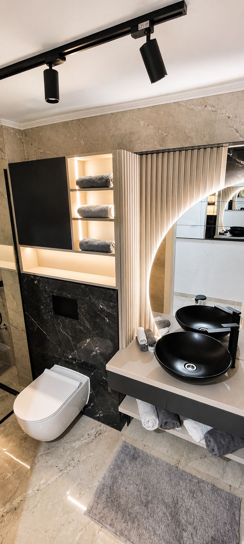 Et stilfuldt badeværelse med en sort vask, toilet og håndklædestang.